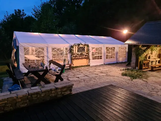 Oświetlony biały namiot przy zabudowaniach o zmierzchu